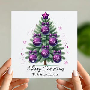 May include: Purple and white Christmas card with a watercolor illustration of a Christmas tree with ornaments that have names on them. The text reads "Merry Christmas To A Special Family".