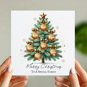 May include: A Christmas card with a green Christmas tree decorated with gold ornaments and bows. Each ornament has a name written on it, including Pete, Kirsty, Bryony, Freddie, Ben, June, and Max. The card reads "Merry Christmas To A Special Family".