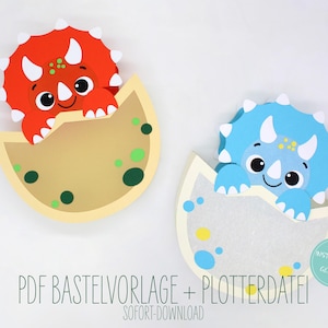 May include: Two dinosaur-themed paper cutouts. One is red, the other is blue, each emerging from a tan eggshell. The cutouts have white horns and spikes, with the text "PDF BASTELVORLAGE + PLOTTERDATEI! SOFORT-DOWNLOAD" below.