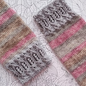 Könnte beinhalten: Zwei Paar gestrickte Socken mit einem grau-rosa gestreiften Muster. Die Socken haben oben einen grauen Spitzenbesatz.