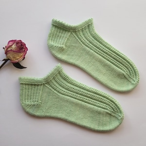 Könnte beinhalten: Ein Paar hellgrüne Knöchelsocken mit Rippenmuster. Die Socken sind aus einem weichen, bequemen Material gefertigt.