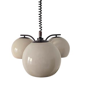 Puede incluir: Una lámpara colgante de tres luces con un cable negro y tres globos de vidrio blanco.