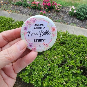 May include: A white button with pink flowers and the text "Ask me about a Free Bible Study!"