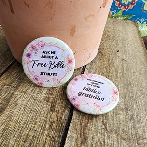 May include: Two round buttons with floral designs. The first button says "Ask me about a Free Bible Study!" The second button says "Preg&uacute;ntame sobre un curso b&iacute;blico gratuito!"