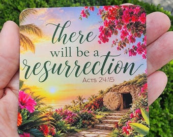 Puede incluir: Un posavasos cuadrado con un paisaje de atardecer vibrante, palmeras, flores de buganvilla rosa brillante y la entrada de una tumba de piedra. El texto There will be a resurrection Acts 24:15 aparece en una fuente cursiva de color verde oscuro.