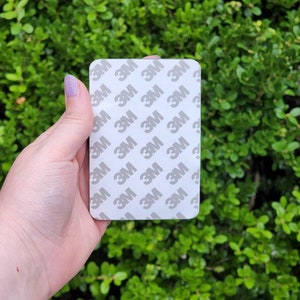 May include: A white rectangular sticker with the 3M logo repeated multiple times.