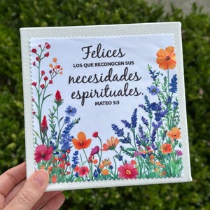 Puede incluir: Arte en lienzo cuadrado con un dise&ntilde;o floral y el texto en espa&ntilde;ol "Felices los que reconocen sus necesidades espirituales. Mateo 5:3." La obra presenta flores coloridas en tonos rojos, naranjas, azules y morados sobre un fondo blanco.