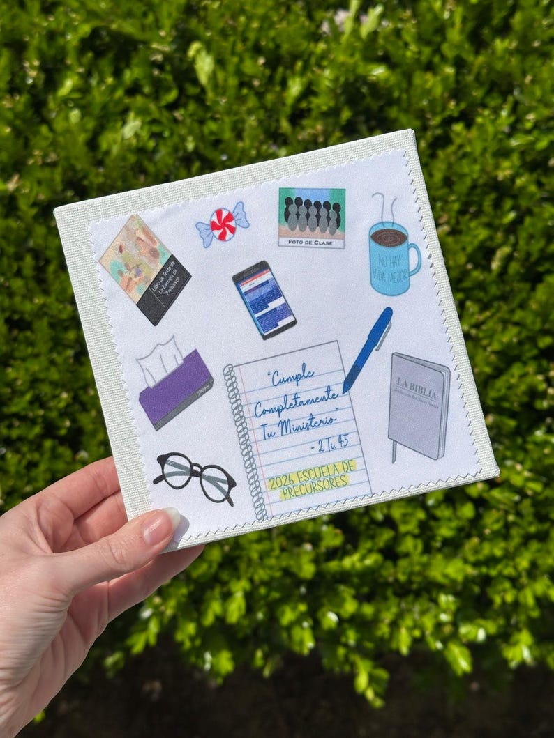 May include: A square, off-white canvas with various colorful stickers. Stickers include a coffee mug, a Bible, a notepad with text, a smartphone, a pair of glasses, and a roll of tissues. The text on the notepad reads "Cumple Completamente Tu Ministerio - 2 T 45".