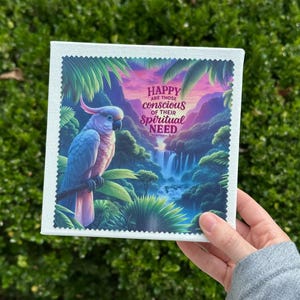 Puede incluir: Impresi&oacute;n en lienzo cuadrada con una colorida ilustraci&oacute;n de un loro azul y rosa en un entorno tropical. La obra de arte incluye cascadas y vegetaci&oacute;n exuberante. El texto dice: "HAPPY are those conscious of their Spiritual NEED."