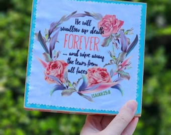 Puede incluir: Un letrero de madera azul claro con un diseño floral y el texto "He will swallow up death FOREVER... and wipe away the tears from all faces ISAIAH 25:8"