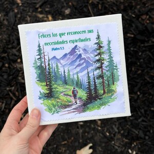 Puede incluir: Impresi&oacute;n en lienzo cuadrada con una ilustraci&oacute;n en acuarela de un sendero de monta&ntilde;a con un excursionista. La impresi&oacute;n incluye el texto "Felices los que reconocen sus necesidades espirituales" y "Mateo 5:3" en verde.