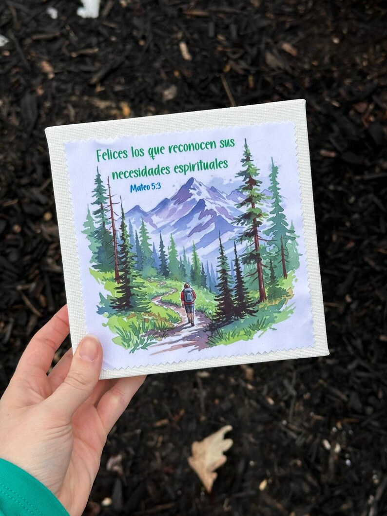 Puede incluir: Impresi&oacute;n en lienzo cuadrada con una ilustraci&oacute;n en acuarela de un sendero de monta&ntilde;a con un excursionista. La impresi&oacute;n incluye el texto "Felices los que reconocen sus necesidades espirituales" y "Mateo 5:3" en verde.