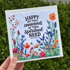 May include: A square canvas print featuring a floral design with the text "HAPPY are those conscious of their SPIRITUAL NEED Matthew 5:3". The artwork showcases colorful flowers in red, orange, blue, and purple.