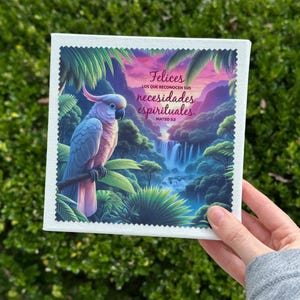 Puede incluir: Impresi&oacute;n art&iacute;stica en lienzo cuadrado con una ilustraci&oacute;n vibrante de un loro posado en una rama, sobre un fondo de una cascada y exuberante follaje tropical. Incluye texto en espa&ntilde;ol.