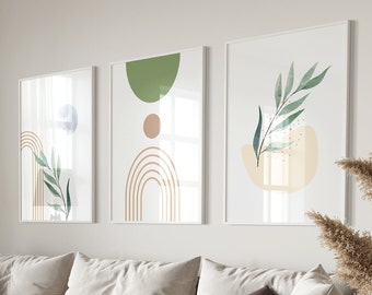 May include: Three framed abstract art prints. Each print features a white background with minimalist designs in shades of green, beige, and brown. The designs include geometric shapes, arches, and botanical elements. The frames are white.