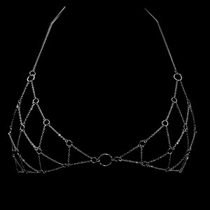 May include: A silver chain body jewelry piece with a circular design. The chain is made of small, interconnected links.