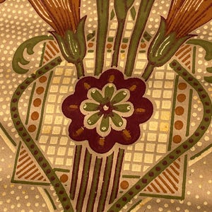 Puede incluir: Un patr&oacute;n de papel tapiz vintage con un dise&ntilde;o repetitivo de flores estilizadas en tonos marrones, verdes y blancos. El fondo es beige claro con un sutil patr&oacute;n de puntos.