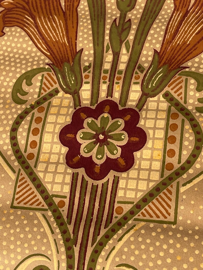 Puede incluir: Un patr&oacute;n de papel tapiz vintage con un dise&ntilde;o repetitivo de flores estilizadas en tonos marrones, verdes y blancos. El fondo es beige claro con un sutil patr&oacute;n de puntos.