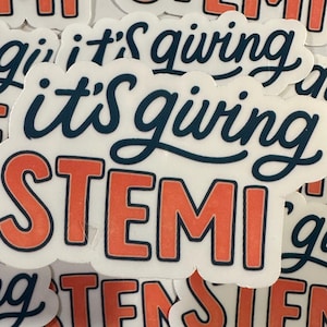 May include: A collection of white stickers with the words "STEMI" in orange letters with a black outline, and the phrase "it's giving" in dark blue script. The stickers are scattered across a surface.