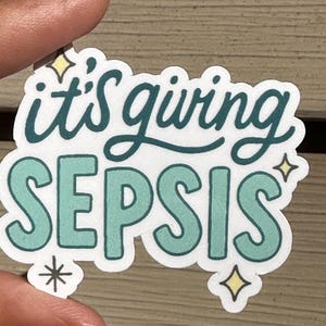 Puede incluir: Una pegatina blanca con la frase "it's giving SEPSIS" en letras turquesas y azul oscuro. La pegatina tiene un borde en forma de nube y detalles de estrellas.