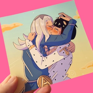 May include: A print featuring an anime-style illustration of two figures embracing and kissing. One figure has white hair and is wearing a blue jacket over a white shirt with black dots. The other figure has black hair and is wearing a blue jacket.