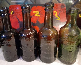 mixed 1920's beer bottles mixed colours and writing.