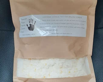 May include: A brown paper pouch with a white label that reads "Handmade Chemical Free Dish Washing Powder". The pouch contains a white powder with small yellow flecks.
