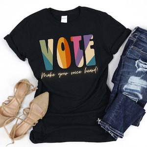 May include: Black t-shirt with a colourful "VOTE" graphic and the text "Make your voice heard!"
