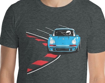 May include: A dark heather grey t-shirt with a blue and white illustration of a vintage sports car driving on a red and white checkered racetrack.