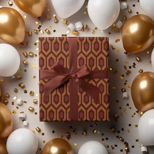 May include: A wrapped gift box with a brown geometric pattern and a matching ribbon is surrounded by gold and white balloons and gold confetti. The balloons are arranged around the gift box, creating a festive and celebratory atmosphere.