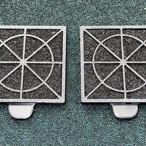 May include: Two silver-colored, square-shaped air filters with a circular pattern of lines and a textured surface.