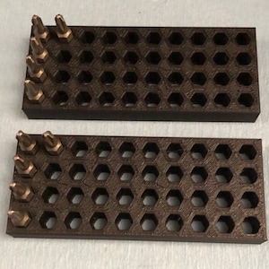 May include: Two black plastic organizers with hexagonal compartments for holding small tools or accessories. The organizers are filled with a variety of small, silver-colored screwdriver bits.