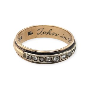 May include: A gold band ring with a row of small diamonds and an inscription on the inside that reads "John in L."