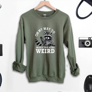a sweatshirt with a raccoon on it next to headphones