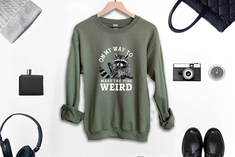a sweatshirt with a raccoon on it next to headphones