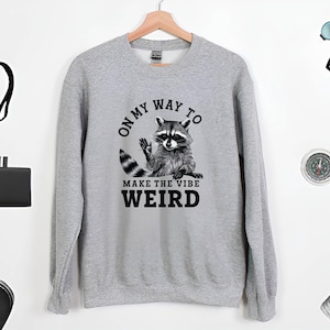 a sweater with a raccoon saying on it