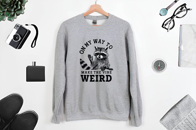 a sweater with a raccoon saying on it