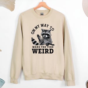 a sweater with a raccoon saying on it