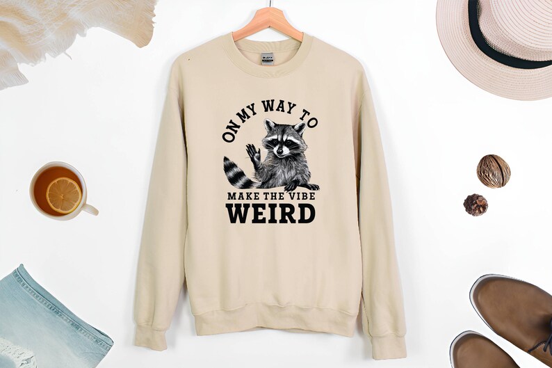 a sweater with a raccoon saying on it