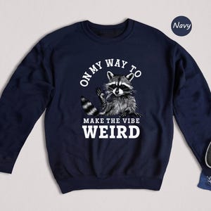 a sweater with a raccoon on it next to a laptop