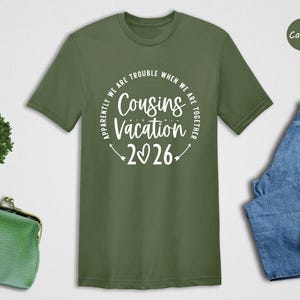 a green t-shirt with a humorous text, a pair of blue jeans, a pair of white sneakers, a green purse, and a small cactus plant.