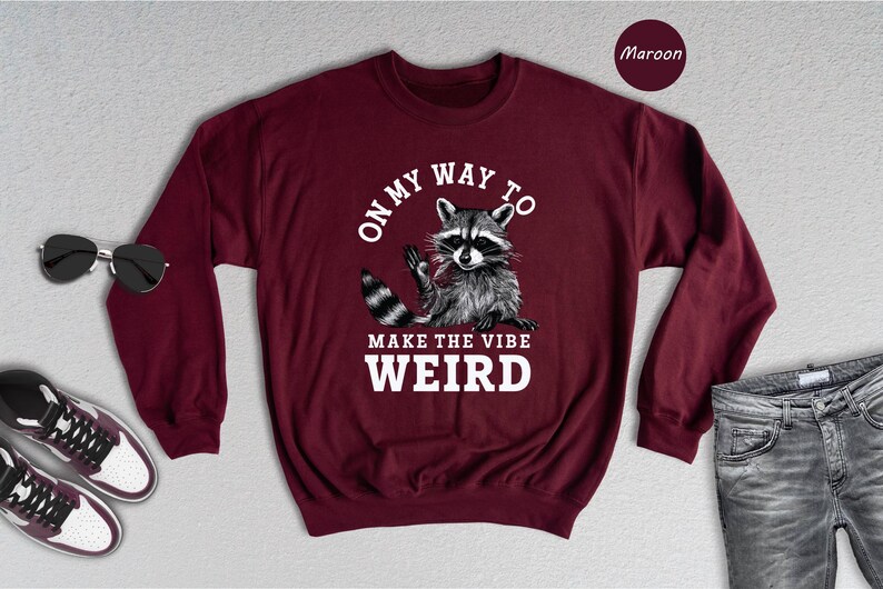 a maroon sweatshirt with a raccoon on it