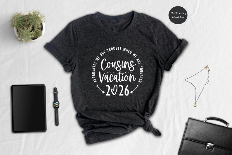 a casual outfit laid out on a white surface, including a black t-shirt with a humorous text, a tablet, a watch, a potted plant, and a black bag.