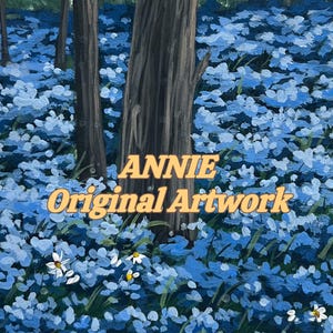 May include: An oil painting depicting a dense forest floor covered in vibrant blue flowers and scattered white daisies, with dark tree trunks rising from the center. The text ANNIE Original Artwork is centered in yellow lettering over the scene.