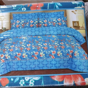 May include: A blue and white floral bed sheet set with red flowers. The set includes a flat sheet, fitted sheet, and two pillowcases.