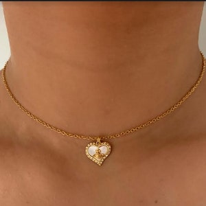 Collar con forma de corazón y esfera dorada de Vivienne Westwood en caja