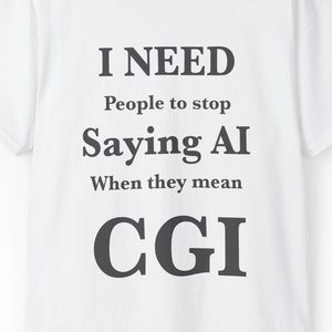 Pode incluir: Camiseta branca com o texto "I NEED People to stop Saying AI When they mean CGI" em letras cinza escuro. A camiseta tem gola redonda e mangas curtas. A etiqueta na parte de trás do pescoço é vermelha com um círculo amarelo.