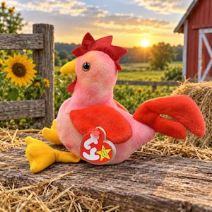 May include: A plush chicken toy with a pink body, bright orange wings, a red comb, and yellow feet. The toy features a heart-shaped tag with the letters ty in white on a red background and the word babies in yellow on a black star shape.