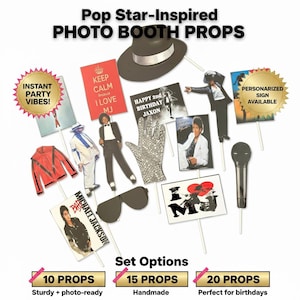 May include: A collection of pop star-themed photo booth props on sticks, including a black fedora, a sequined glove, a microphone, sunglasses, a red jacket, and various signs with text like 'KEEP CALM because I LOVE MJ' and 'HAPPY 2nd BIRTHDAY JAXON'.