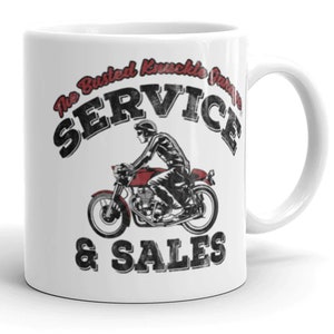 Puede incluir: Taza de cerámica blanca con un gráfico en negro y rojo de una motocicleta y el texto "The Busted Knuckle Garage Service & Sales".